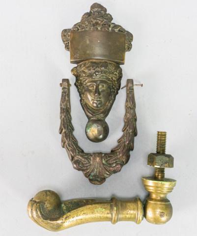 2 Figural Brass Door Knockers: 2 figural brass door knockers. Woman's face, 7 1/2"L; hand, 7 1/4"L. Knocker detached / missing screws on face door knocker. From the collection of the Salmagundi Club.