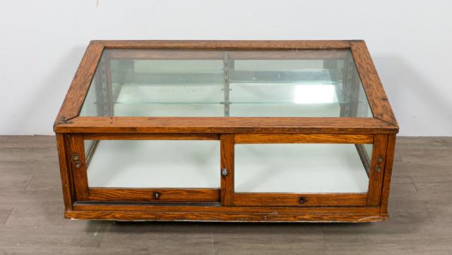 Museum Tabletop Display Vitrine: Museum tabletop display vitrine. American, Early 20th Century. Oak supports, glass top, sides, and sliding front doors that lock with included key. Two glass shelves. Light fixture is installed but ha