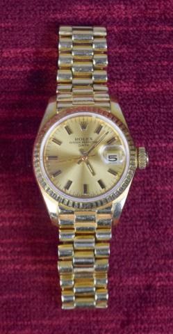 Ladies 18K Gold Rolex Watch: Ladies 18k yellow gold Oyster Perpetual date adjusted wrist watch. Marked on clasp 8570 Rolex Geneva Rolex sa 750 Swiss made (hallmarks) 18k. 67.4 grams. With extra links. Small flake in crystal betwe