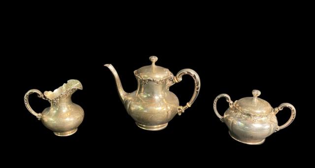 Towle Sterling 3 Piece Tea Service: A Towle sterling silver teapot, lidded sugar, and creamer. Each decorated with scrollwork on rims and handle. All marked on the underside with Towle pictorial mark , "Sterling" and "7619". Weight incl