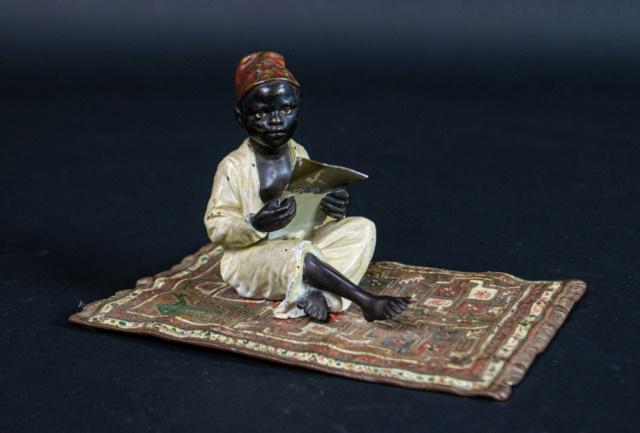 Franz Bergman Austrian Cold Painted Bronze: Franz Xavier Bergman (Austrian, 1861-1936). Cold painted bronze boy on a rug. Stamped on the boy's clothing and on underside of the carpet with Bergman's B in vase mark and Geschutzt. 6 3/4" x 4 1/4" 