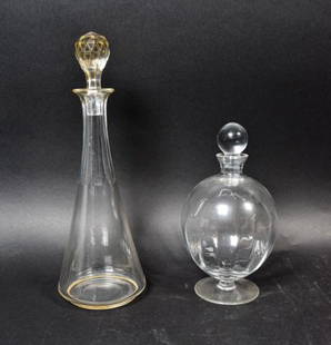 2 Glass Decanters: A Glass decanter with cut stopper and raised decoration. A Mikasa round glass decanter. Tallest: 14" H.