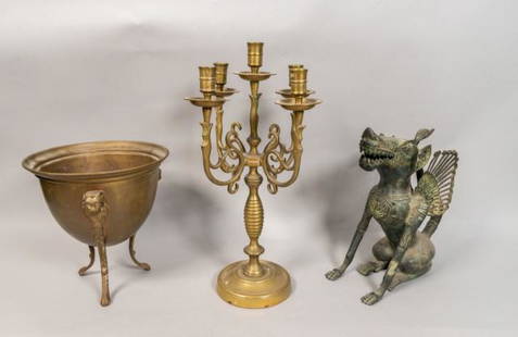 3 Bronze Decorative Items: Bronze candelabra. Bronze three footed bottle holder with lion head decoration. Patinated bronze Meso- American style winged beast sculpture Bottle Holder: 15" Diameter. Wax residue on the body of