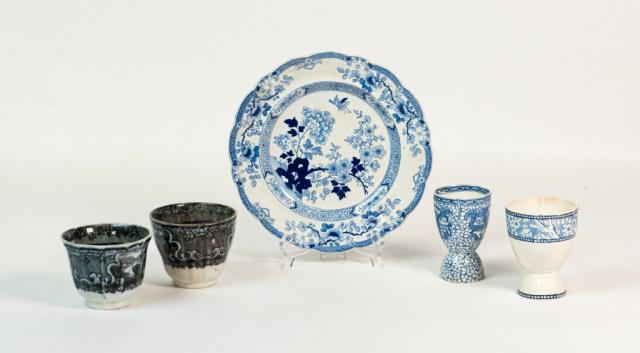 Collection of English Stoneware: 2 egg cups, 2 cups, Luncheon plate. Repair to 1 cup, chip to the rim of egg cup, line to 1 egg cup. Crazing to most articles.