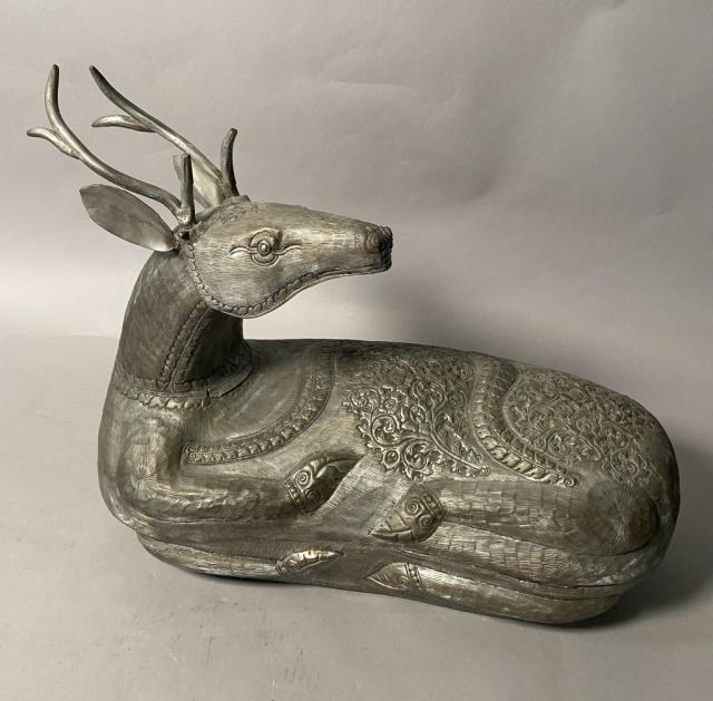 Ornately Tooled Deer Cornucopia: Ornately tooled deer cornucopia. Early 20th Century. A metal deer sculpture that opens up to reveal a inner storage chassis. Stylized filigree and features throughout. Some wear on right hindleg. 18"