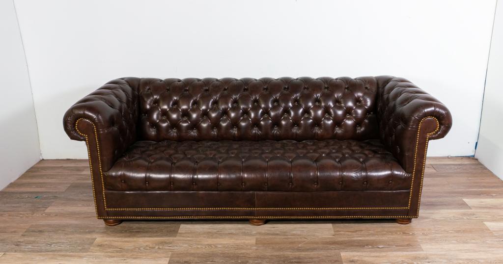 Leathercraft Chesterfield Style Tufted Sofa: Leathercraft Chesterfield style tufted sofa. American, late 20th century. Burgundy leather, tufted with brass studs along couch arms and bottom of sides. Wear and wrinkling to upper left side. 30" H x