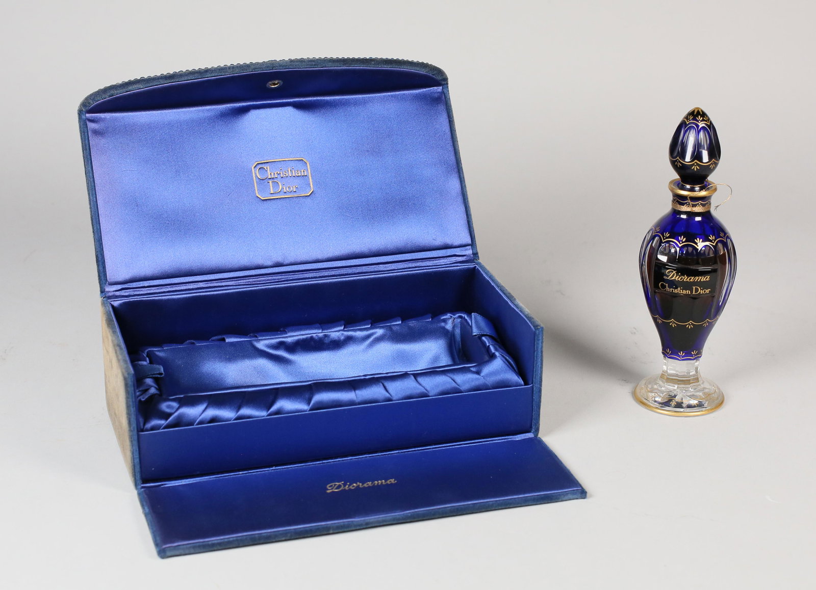 Baccarat Dior Diorama Perfume Bottle: Baccarat for Christian Dior Diorama, cased crystal perfume bottle and stopper, cobalt blue cut to clear, gilt detail and labeling, blue velvet box. Baccarat mark on the underside of bottle. Mostly ful