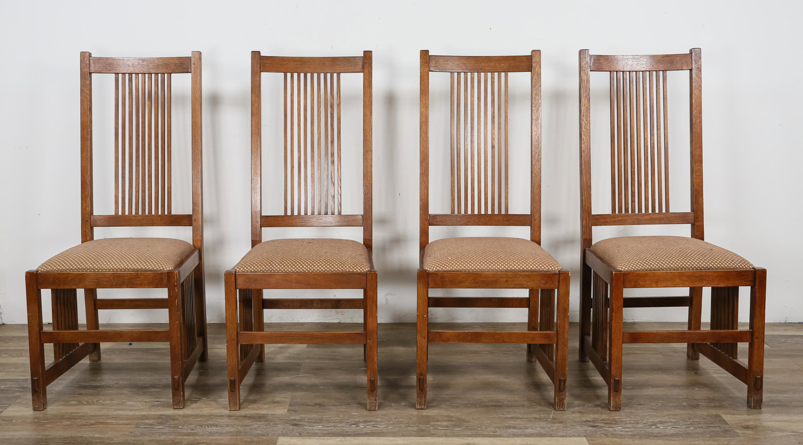 Four L. & J.G. Stickley Audi Dining Chairs: 4 L. & J.G. Stickley / E.J. Audi (1974-). Spindle back dining chairs of quarter sawn oak. "Stickley" branded stamp and "March 17 1998 #32" brand. Rubbing and stain loss throughout. Fabric cushions hav