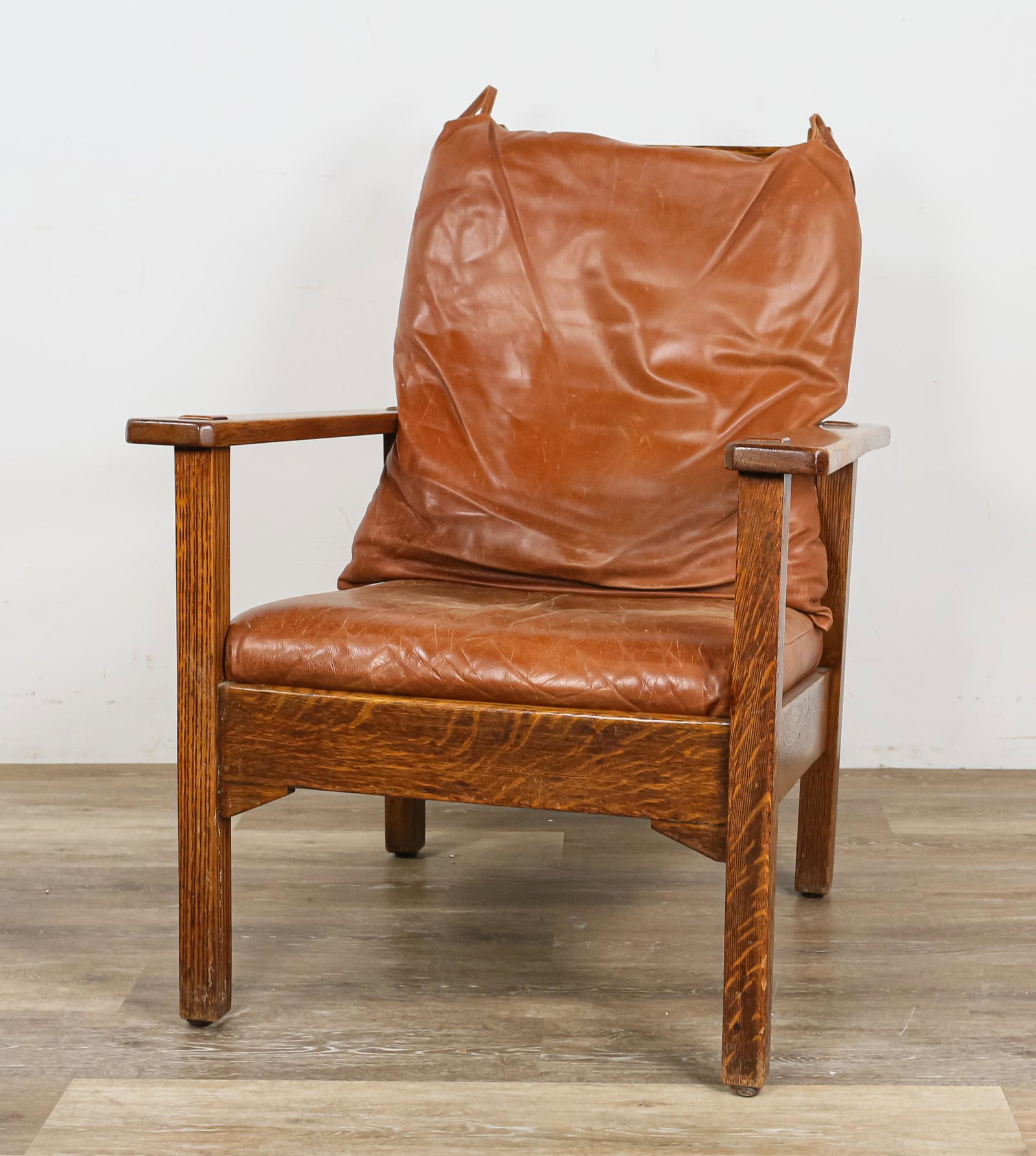 Stickley Brothers Open Arm Morris Chair: Stickley Brothers (Grand Rapids, MI, 1891-1954). Morris chair of quarter sawn oak. Replaced leather cushions. Metal "Quaint Furniture" tag. Branded "430-788". Wear to top rail of back. All legs are wo
