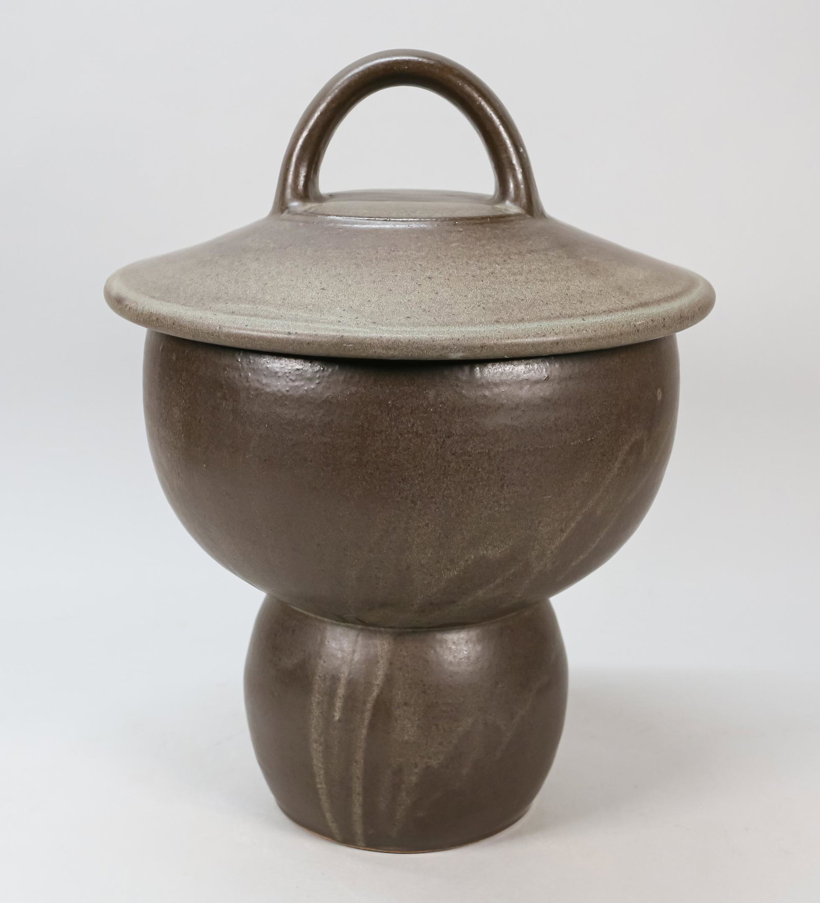 Chris Gustin Covered Pottery Jar: Chris Gustin (American, Chicago, b. 1952) footed pottery jar. Gray glaze with white interior. Signed and dated 79 on the underside. 17" H x 11" diameter. Large line to the bowl.