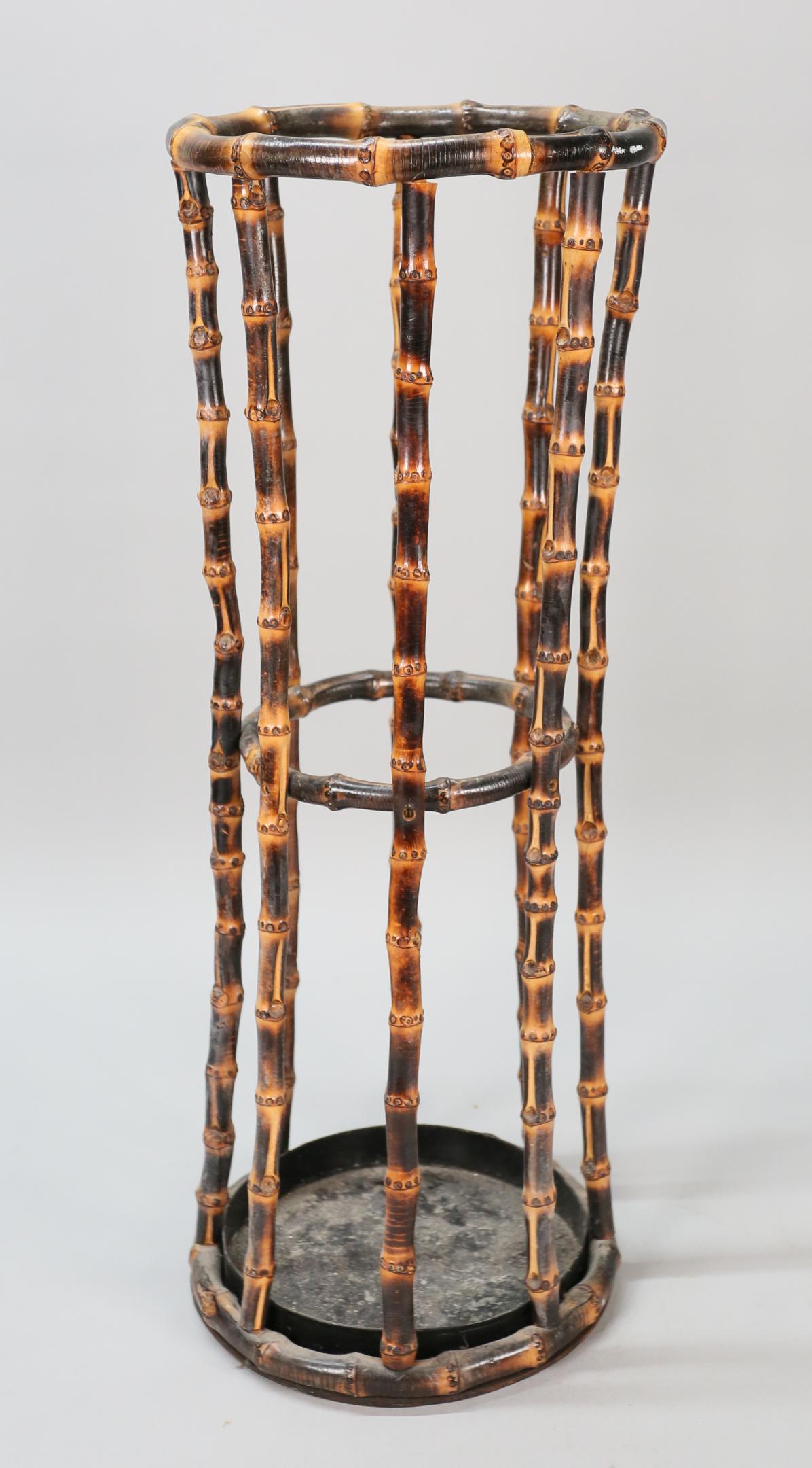Bent Bamboo Umbrella Stand: Bent bamboo umbrella stand. 20th Century. Bent bamboo stand with metal liner and wooden base. White mark on top edge, wear and staining to metal liner. 23 1/2" H x 9" diameter of top
