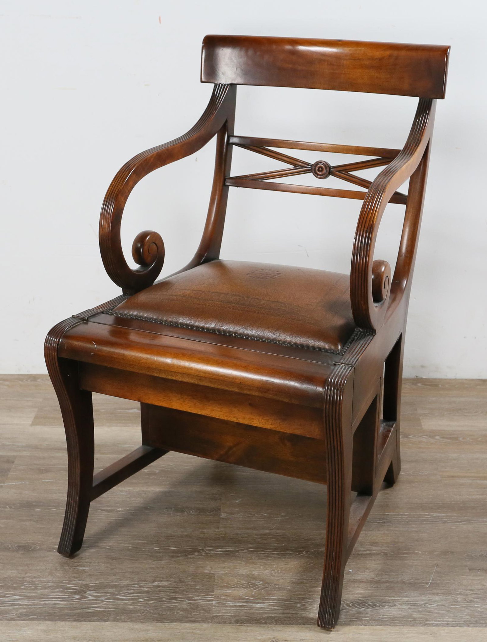 Regency Style Metamorphic Library Chair and Ladder: Regency style metamorphic library chair and ladder. 20th century. Scrolled and reeded arms, leather cushioning, saber legs. Converts into step ladder with inset leather steps. Scratches and marks to f