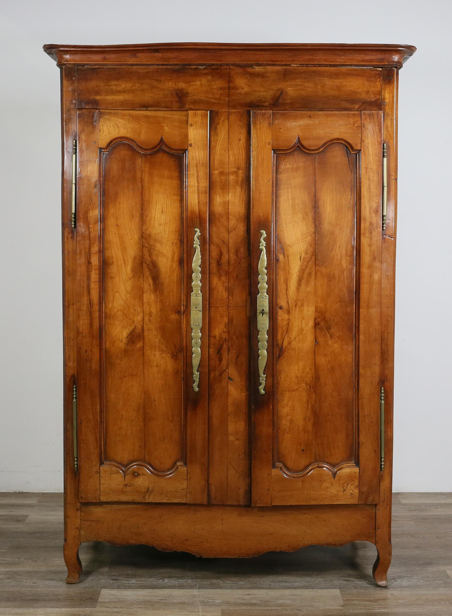 French Provincial Armoire: French Provincial armoire. Fruitwood and engraved escutcheons. Splitting and cracks along length of crown, which does not sit flush on top. Original shelves replaced with plywood. Scratches and marks 