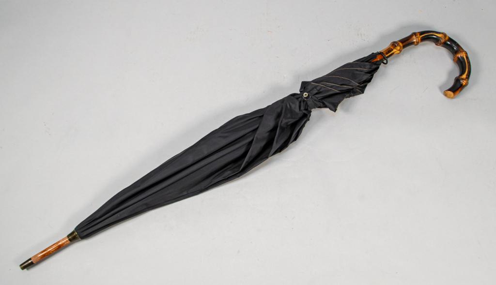 Brigg London Carved Bamboo Umbrella: Carved bamboo and nylon umbrella. Marked with "Brigg. Made in England" on the top of the handle "Brigg London" on metal runner. Small button and metal closure. Stitching worn and frayed, wood worn on 