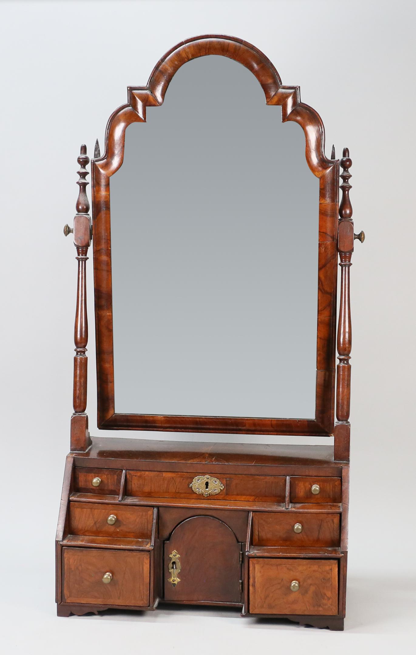 Burled Mahogany Shaving Mirror: Burled mahogany shaving mirror. 19th century. 7 drawers and one cubby hole door. Key is included. Staining and oxidization to mirror. Splitting and cracks to top of shaving stand. Splitting above back