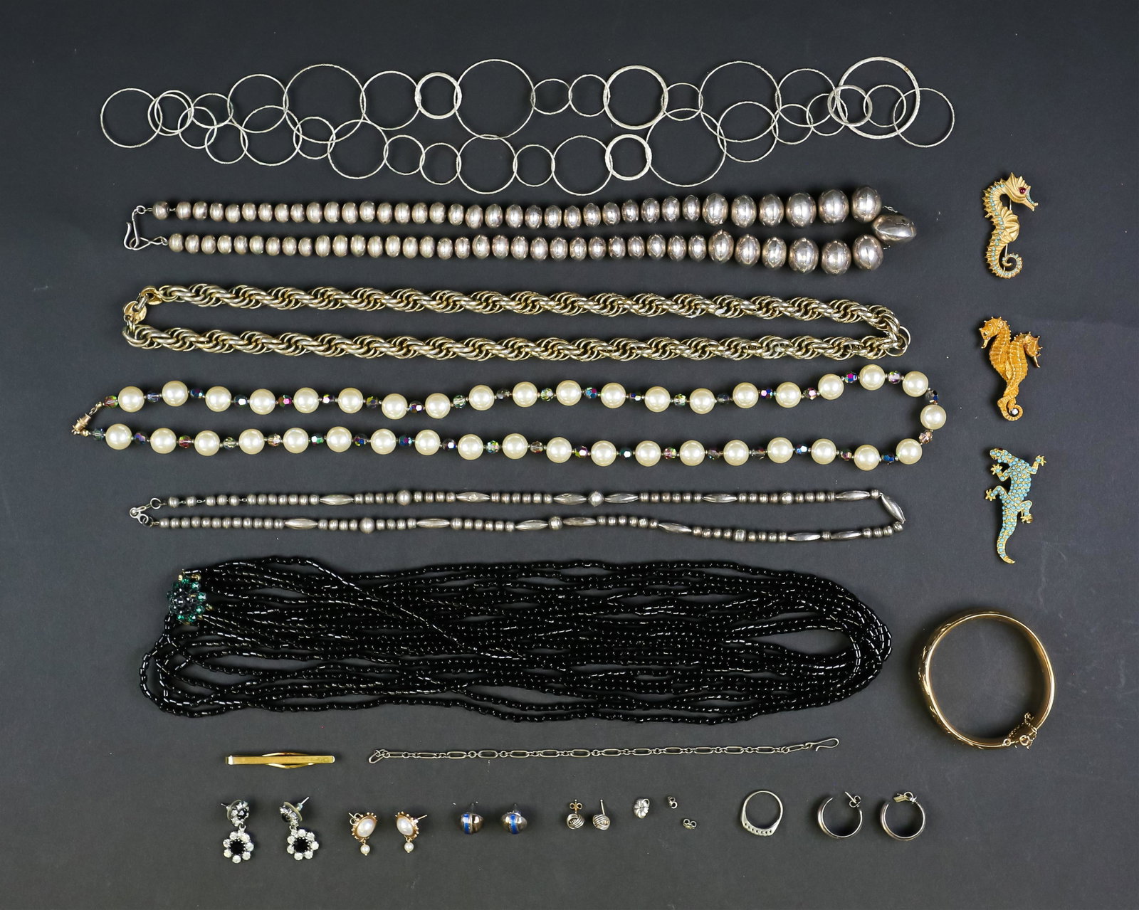 Lot of Costume & Beaded Jewelry: Lot of costume and beaded jewelry including multi-strand bead necklace with green stone center, Monet gold tone necklace, 2 silver tone beaded necklaces, faux pearl necklace, Hayward 12k gold filled b