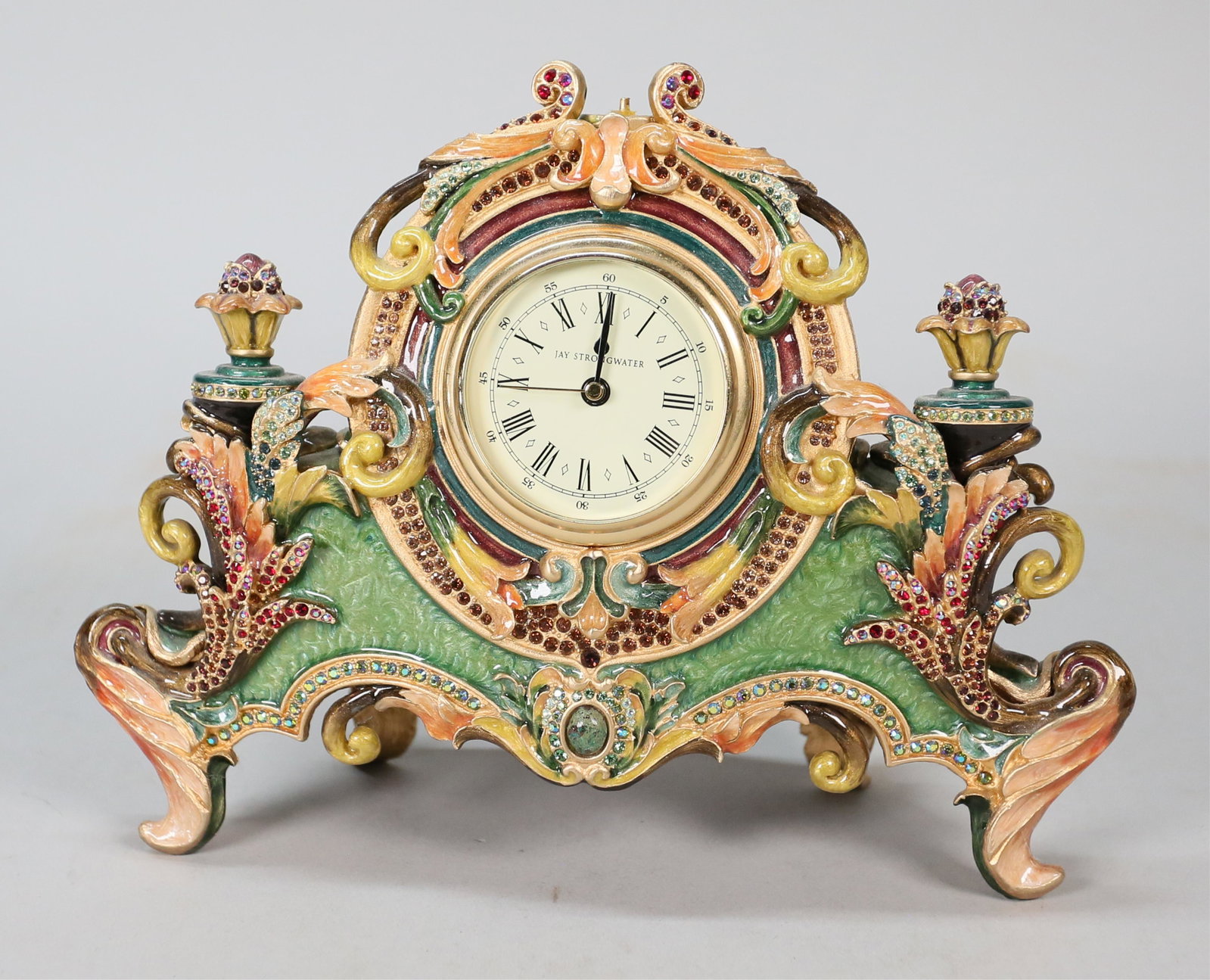 Jay Strongwater Limited Edition Clock: Jay Strongwater (American, 1960-). Limited edition enamel and jeweled clock with floral finials. With Jay Strongwater label, numbered 60/350, 7"H x 8 3/4"W. Top center finial missing.