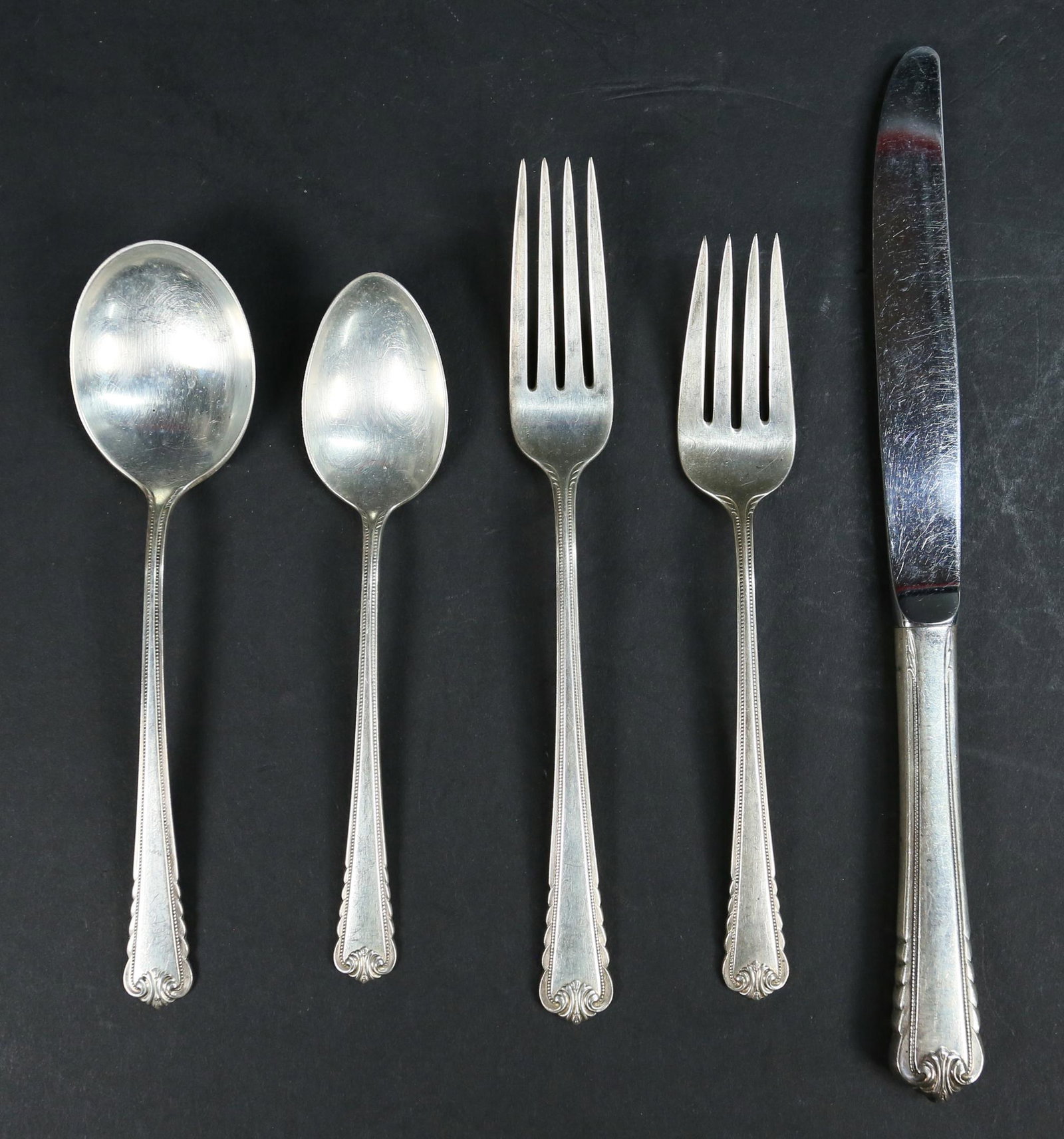 40 Pieces Rogers Moonbeam Sterling Flatware: 40 pieces Rogers sterling silver flatware in the Moonbeam pattern. 8 soup spoons, 8 knives, 8 forks, 8 teaspoons, 8 salad forks. Knives 9"L. 1209 grams not including knives.