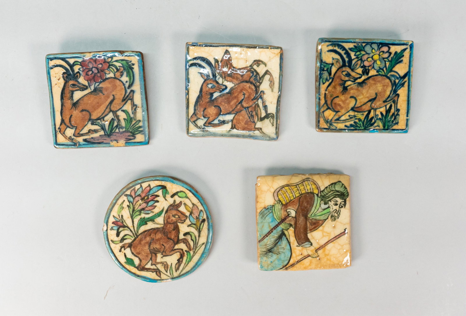 5 Glazed Clay Tiles: Grouping includes one tile depicting a man, four tiles depicting animals, chips and scratches on all, 4"x4"