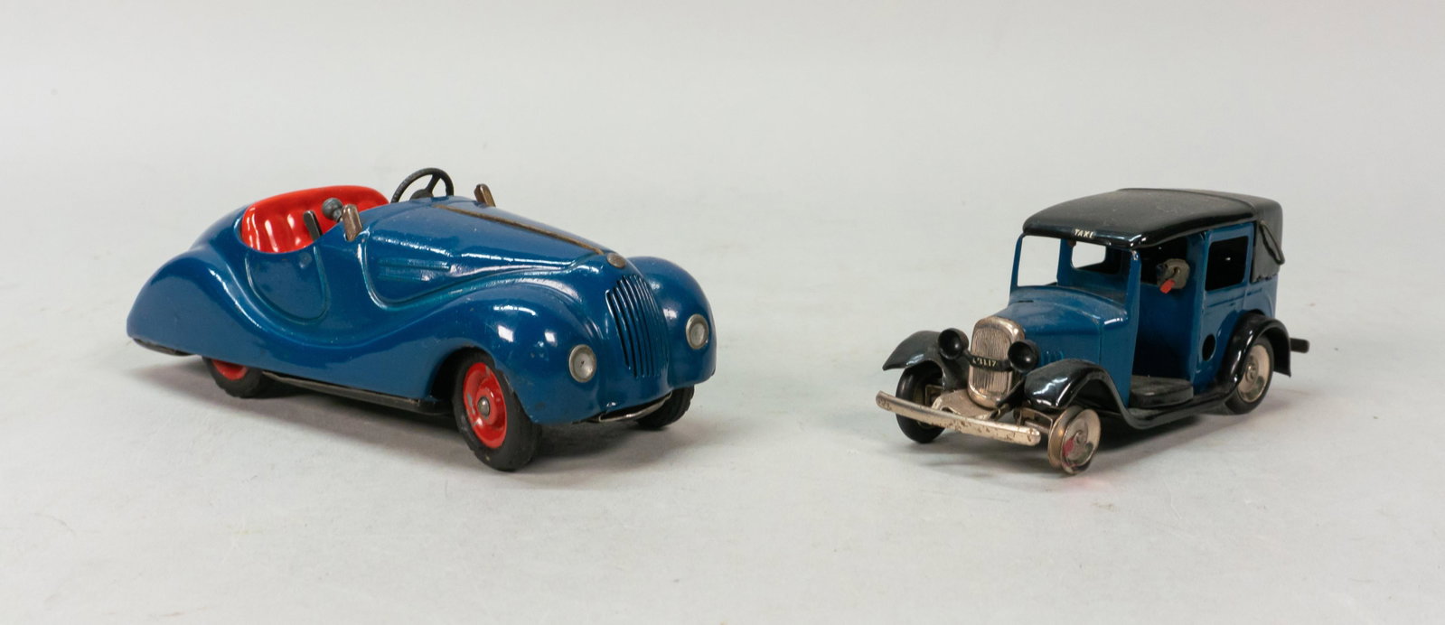 Tri-Ang Minic & Shuco Examico Wind-Up Toy Cars: 2 wind-up tin toy cars. Shuco Examico 4001 wind-up car, 5 1/4"L; Tri-Ang Minic wind-up taxi, 4"L. Both with original keys. Paint loss to wheels on Shuco car, missing windshield; wear to chrome on Tri-