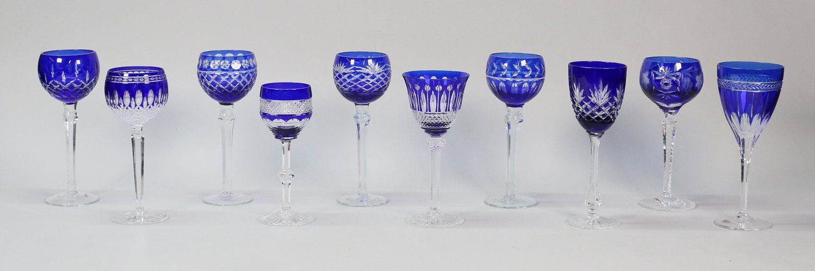 10 Pieces Cobalt Cut to Clear Stemware: 10 pieces cobalt cut to clear stemware. Including Faberge, Waterford, Wedgwood, Natchtmann, 2 Saint Louis, and 4 unsigned. Tallest 8 1/2"H.