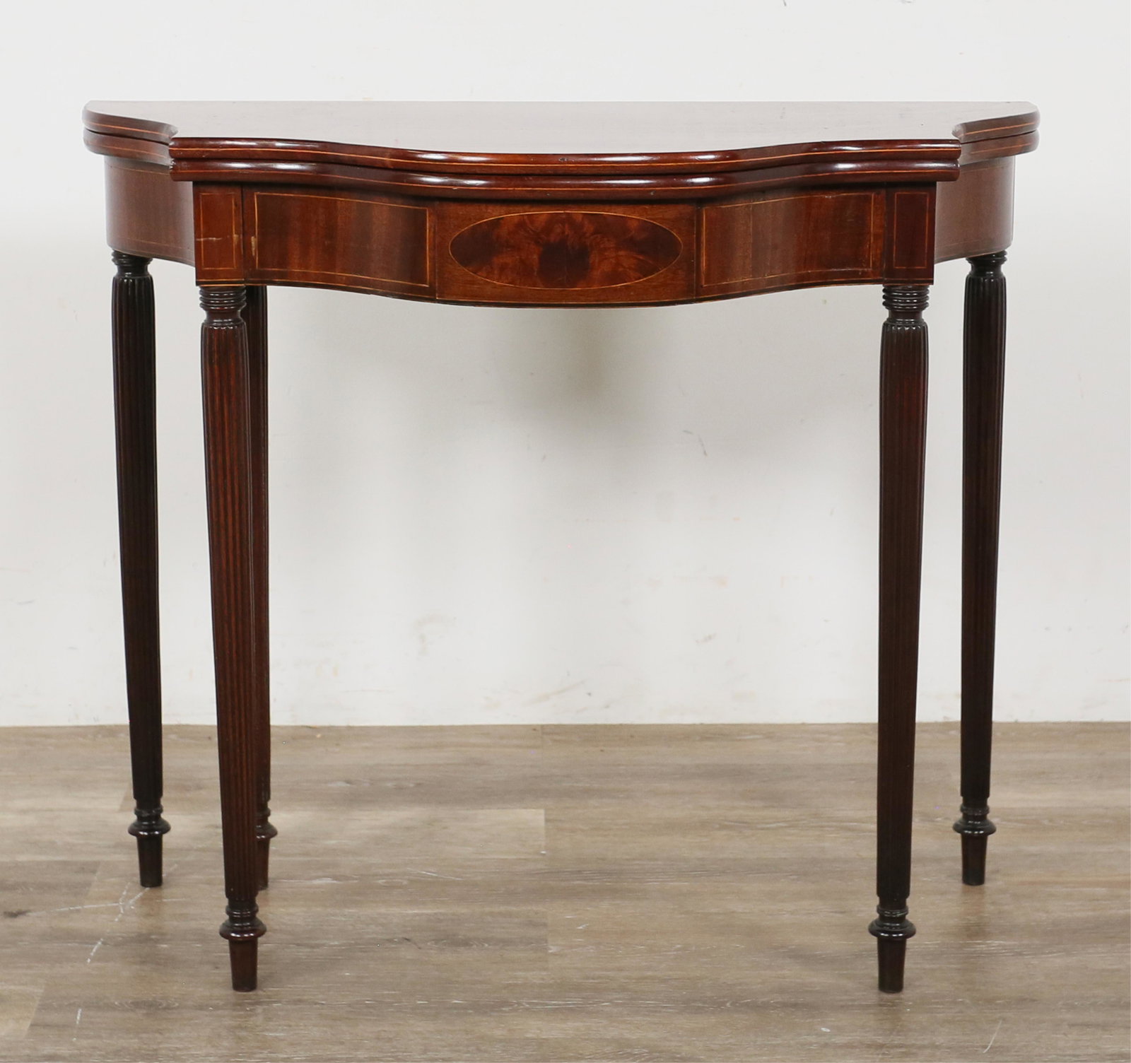 Sheraton Style Fold Top Console: Sheraton style fold top console. American, early 20th century. Mahogany with burl and banded inlays, reeded colonnade legs, gate leg extension. Chips and indents to wood on front and back edges of top