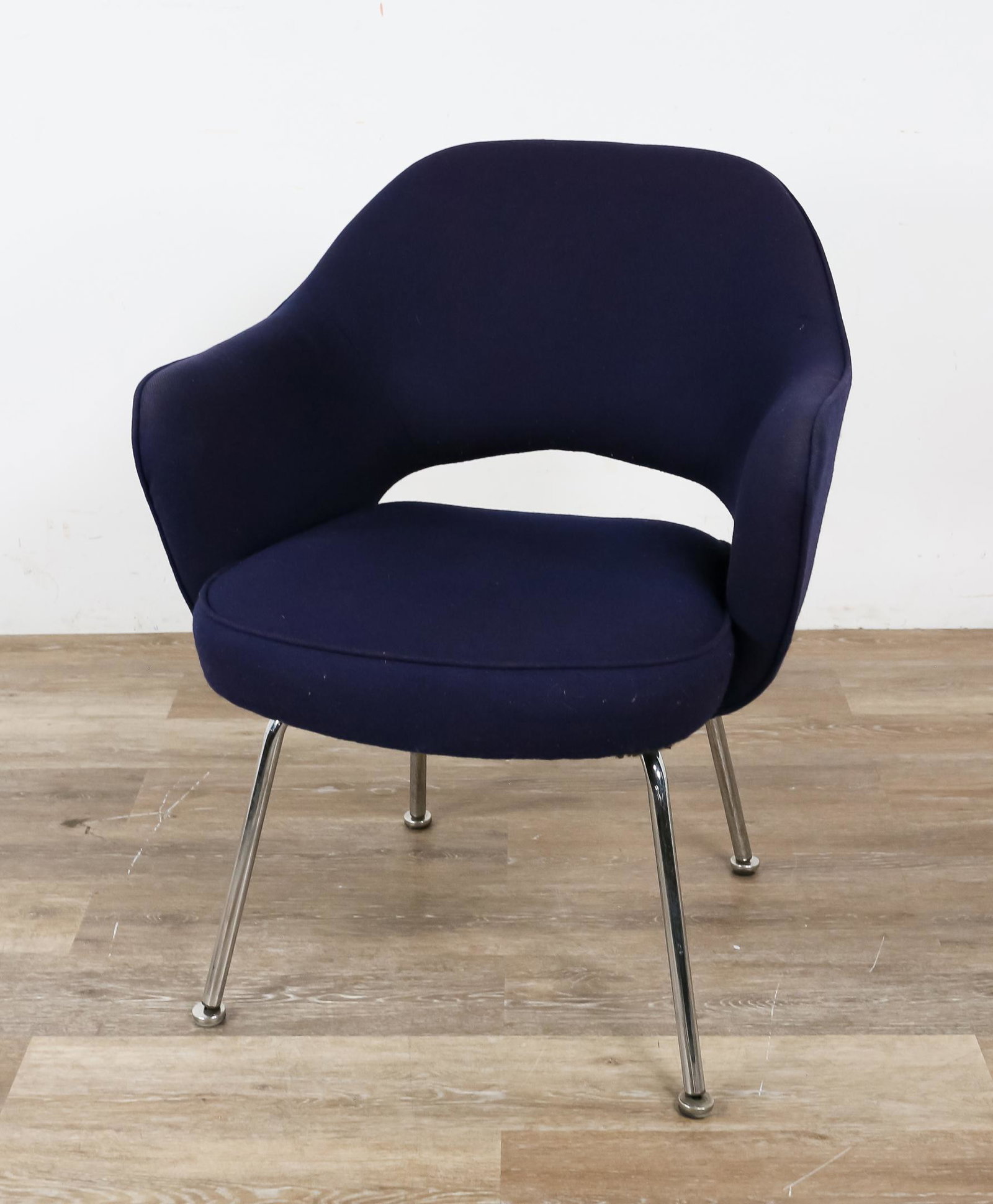 Eero Saarinen Style Executive Armchair: Eero Saarinen (Finland 1910-1961). Tubular chrome legs and dark blue upholstery. No label present. Surface spotting and scratches to chrome. Slight fading to upholstery on arms.31" H x 25" L x 20" W