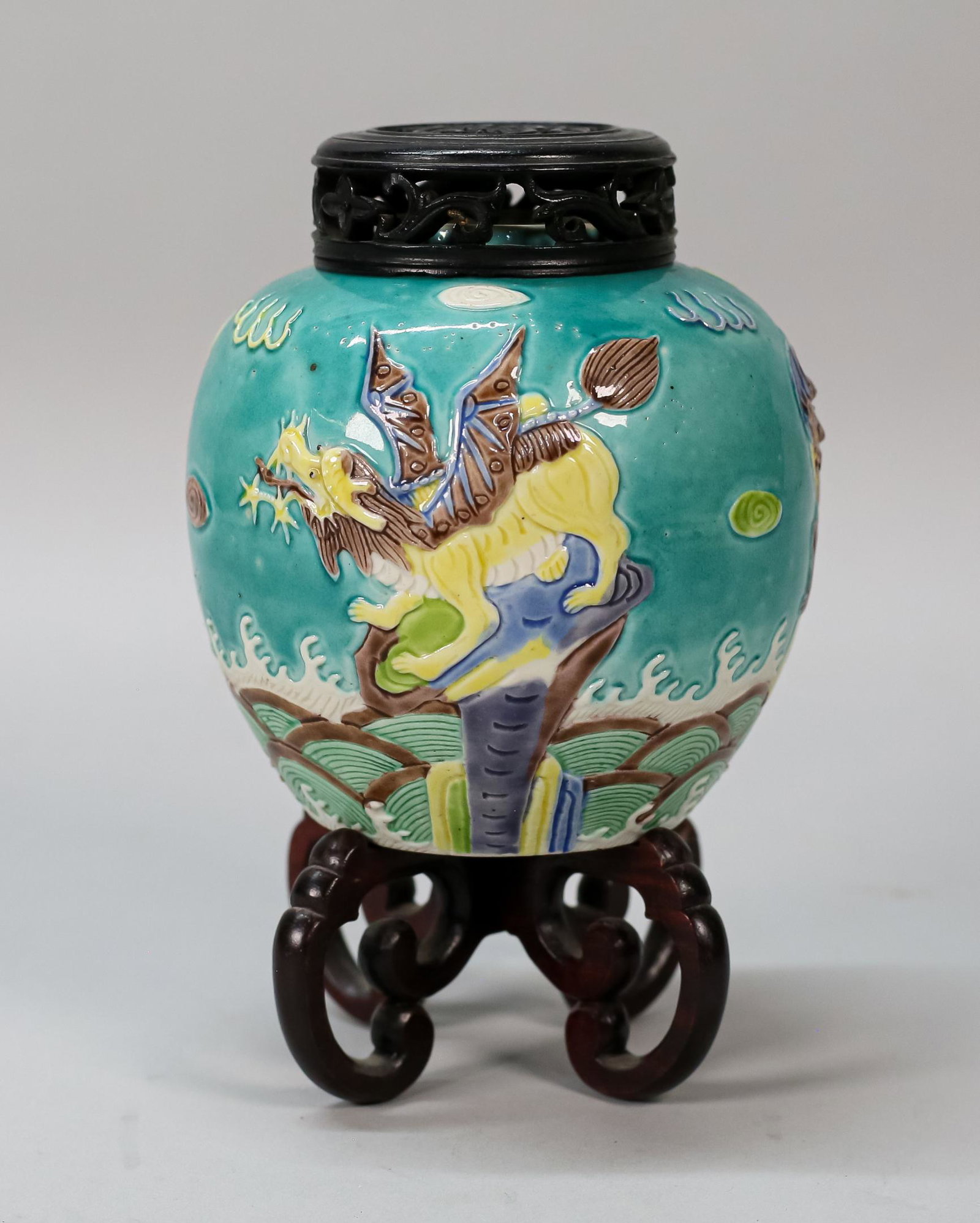 Chinese Porcelain Ginger Jar: Chinese porcelain ginger jar, with dragon and foo dog motif. With wooden lid, on wooden stand. Wang Bing Rong Zuo mark to underside. 5 3/8"H including lid (with stand 7 3/4"H). Crack to wooden lid.