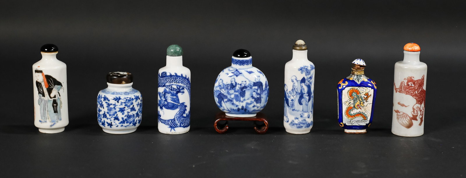 7 Porcelain & Enamel Snuff Bottles: 7 Chinese porcelain and enamel snuff bottles. 3 porcelain bottles with hardstone tops, unmarked; 2 porcelain bottles with Yongzheng marks; blue and white porcelain bottle with 4 character mark; enamel