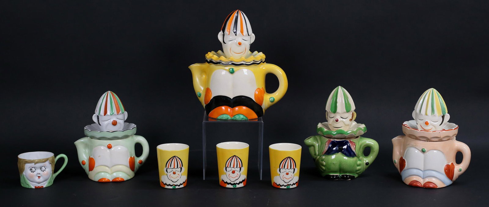 8 Pieces Japanese Clown Porcelain: 8 pieces of Japanese porcelain. 3 Takito clown cups, 4 clown juicers, Nippon child cup. Largest juicer 9 1/4"H; Nippon cup 2 3/8"H.Crazing to 3 clown cups and line to 1; juicers all sealed with museum