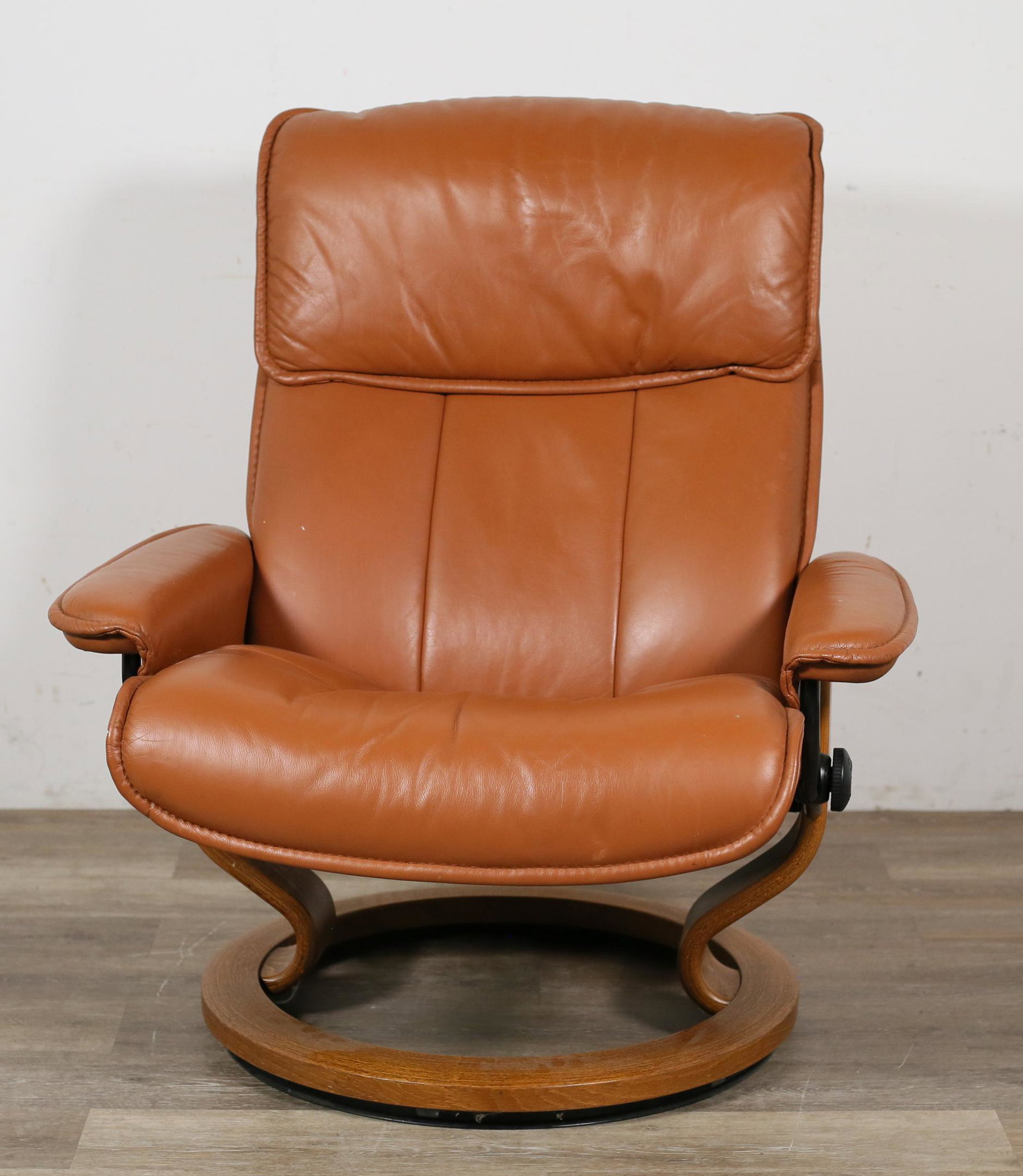 Ekornes Stressless Lounge Chair: Ekornes Stressless lounge chair. Norwegian, 20th century. Reclining lounge chair with adjustable reclining mechanism and circular revolving base. Wear and wrinkling to leather throughout chair. Small