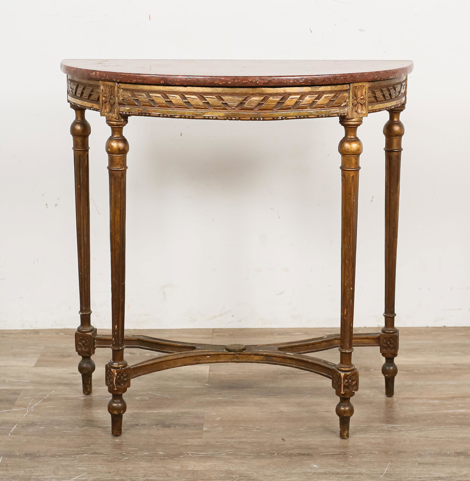 Louis XVI Style Marble Top Demilune Console: Louis XVI style marble top demilune console. 20th century. Red speckled marble top sitting on carved gilded base. Chips and losses to marble on front and back left edges. Losses to gilt paint througho