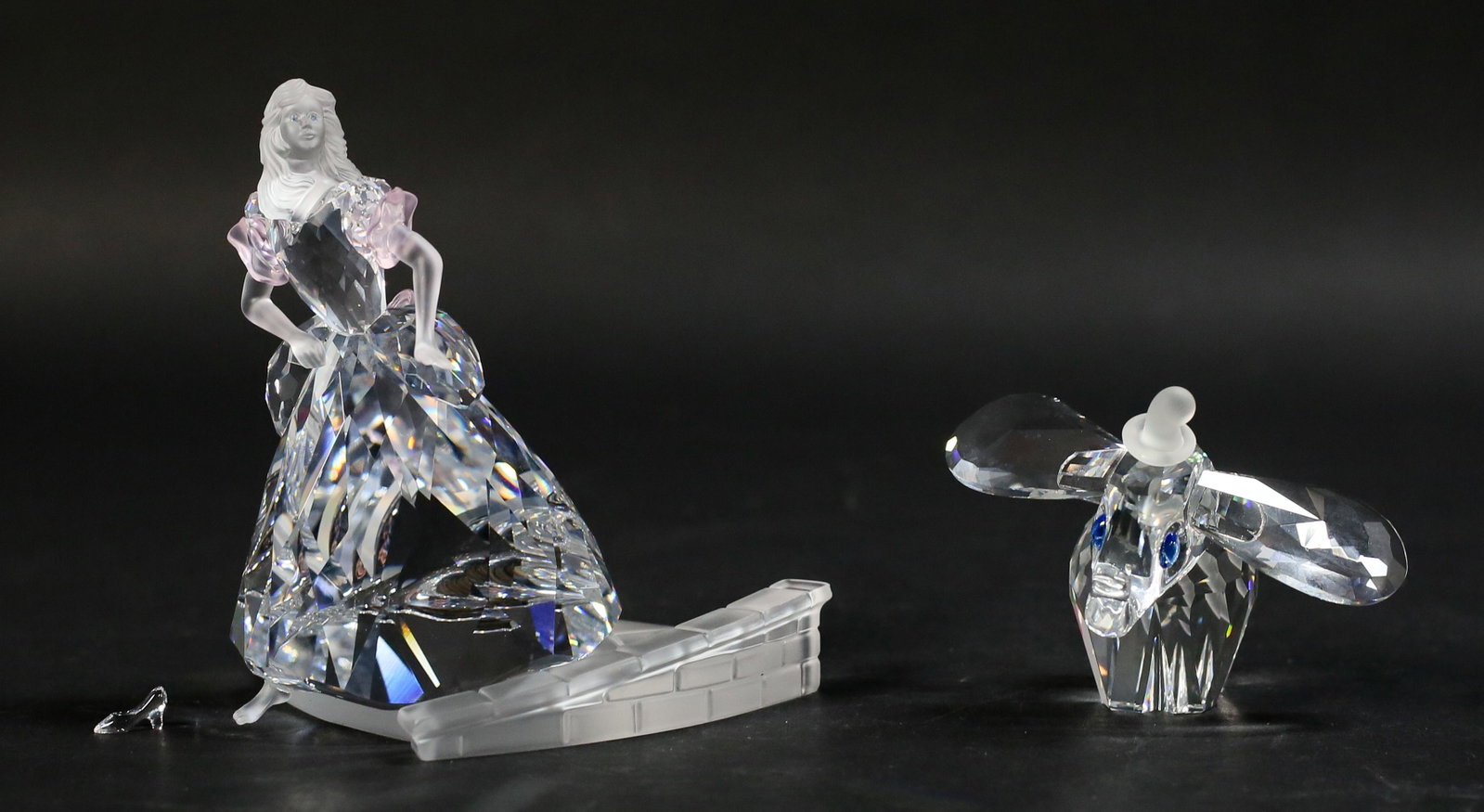 2 Swarovski Disney Figurines Dumbo & Cinderella: 2 Swarovski crystal Disney figurines. Dumbo Elephant, 2 1/2"L x 2 1/4"H, Cinderella with glass slipper, 4 1/8"H. Dumbo with Swarovski swan and Disney marks, Cinderella with swan mark. Both with origin