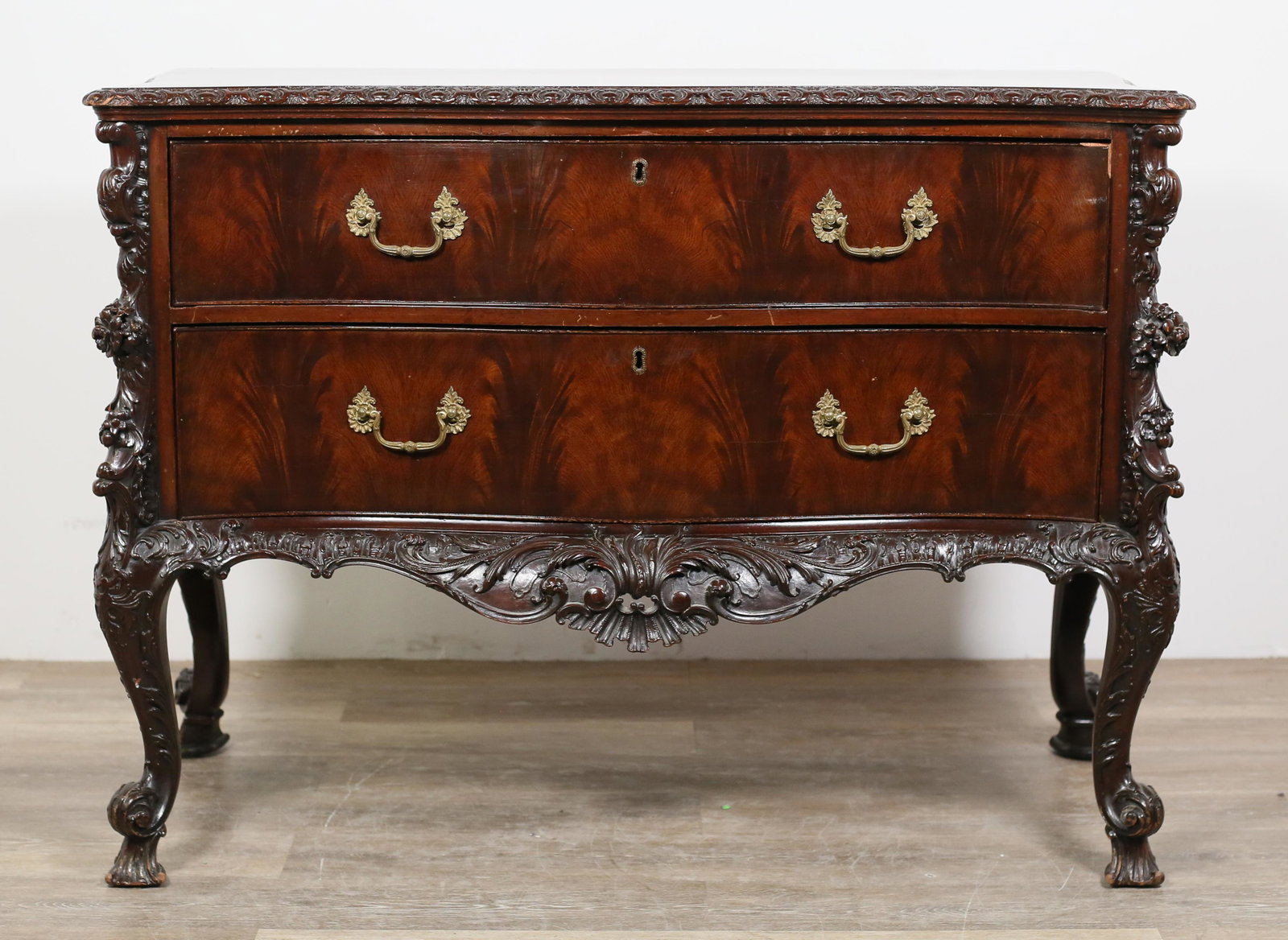 Rococo Revival Mahogany Chest of Drawers: Rococo Revival mahogany chest of drawers. Continental, 19th century. Serpentine form, ornate mahogany carvings, two burled drawers. Scuffs, scratches and wear to wood throughout top of chest. Marks, n
