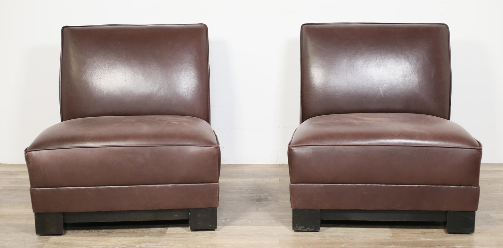 Pair of Ralph Lauren Leather Lounge Chairs: Pair of Ralph Lauren leather lounge chairs. 21st century. Chocolate brown leather, black block feet. Ralph Lauren labels on underside of both chairs. Wrinkling, scratches, scuffs, and wear to leather 
