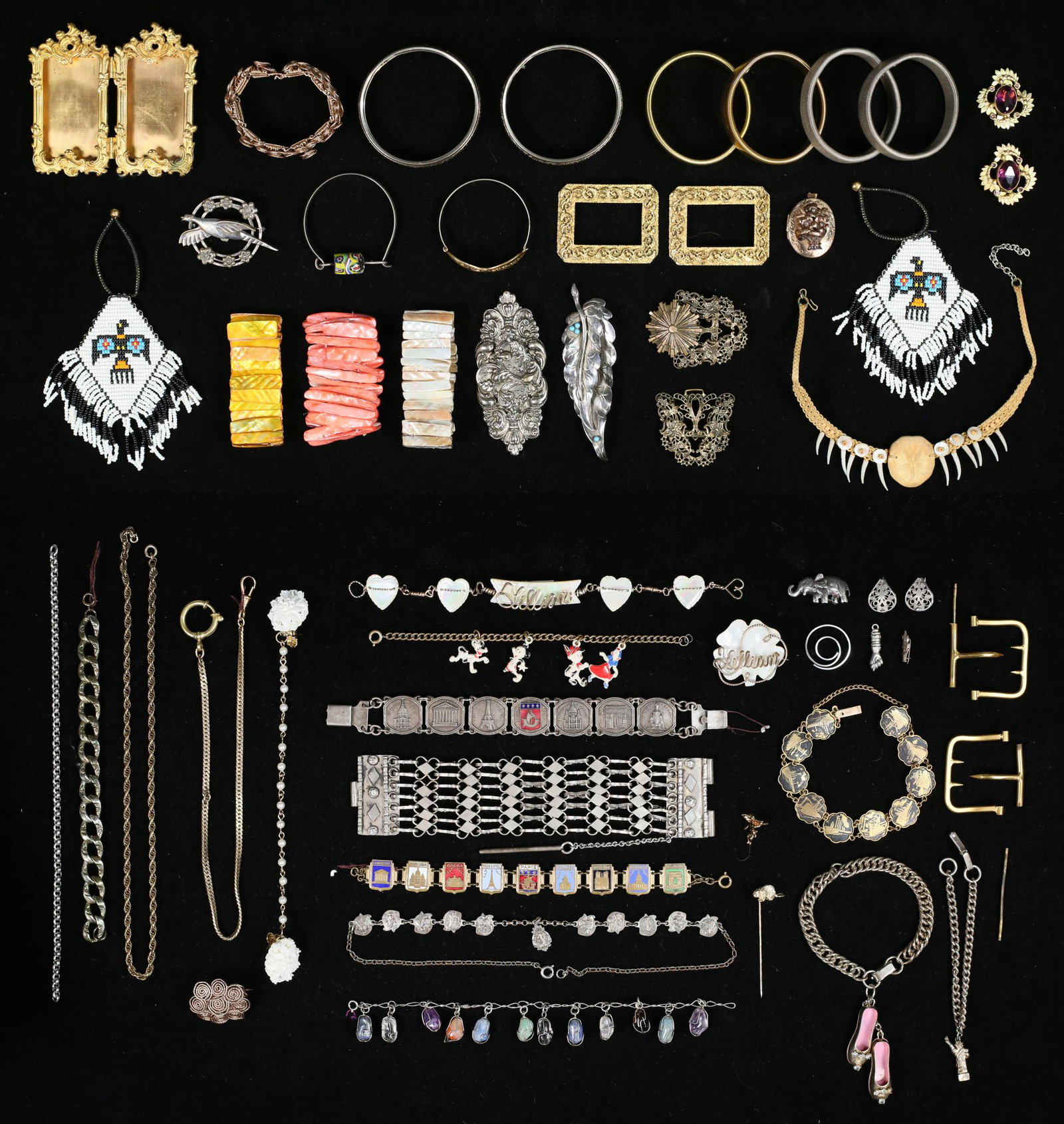 Grouping of Jewelry and Accessories: Lot includes gold and silver tone bracelets, brooches, pins, shoe clips, wood and teeth bracelet, souvenir charm bracelets, shell bracelets, metal locket, gold tone folding frame measures, 3 7/8 wide.