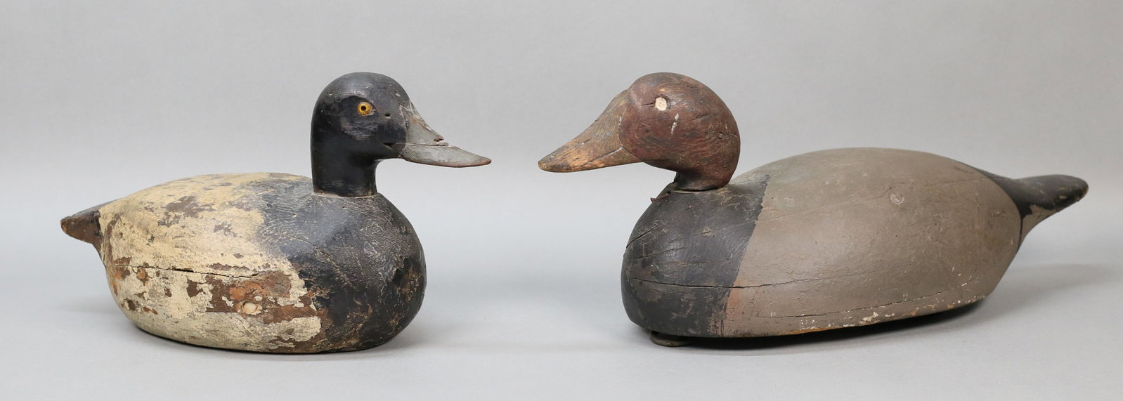 2 Wood Carved Duck Decoys: 2 carved wood duck decoys. Both unsigned. 19"L and 14"L. Paint loss and chips to both; smaller split to underside, chips to beak, chips to tail feathers; larger chips and splits to body, large chips t
