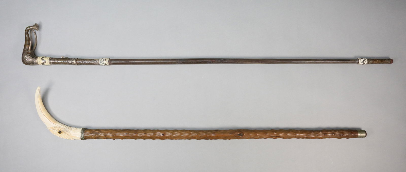 2 Figural Canes: 2 figural canes / walking sticks. Wooden cane with Indian silver and brass elephant form handle and silver and brass tip, 42"L; naturalistic wooden cane with carved bone bird form handle, 37 1/8"L. Lo