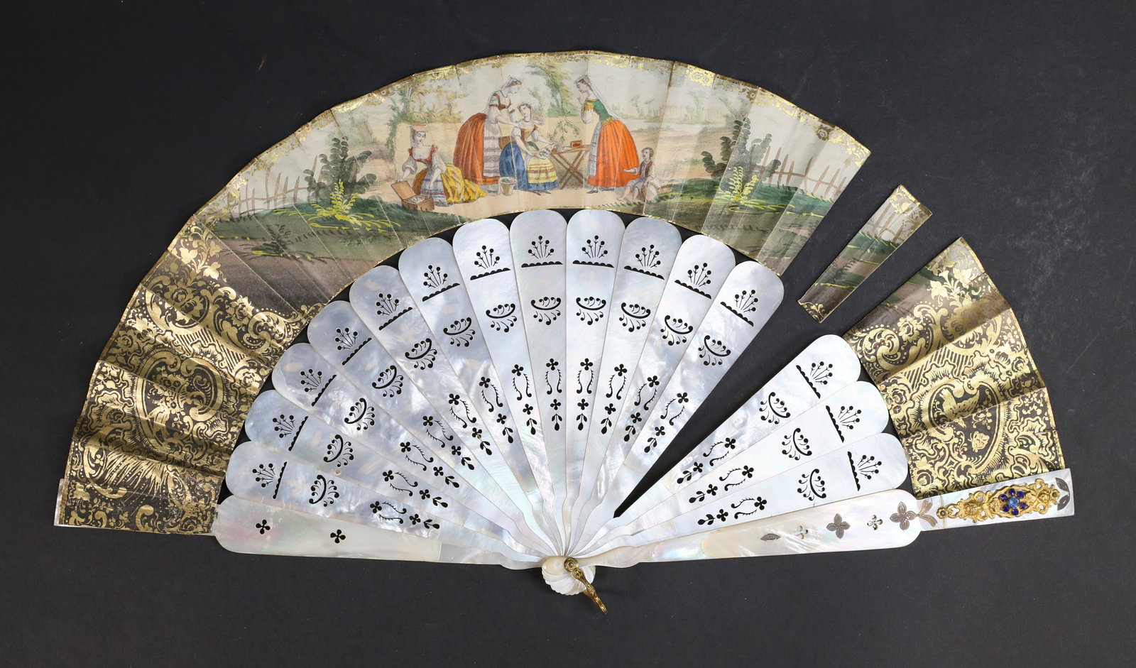 Hand Painted Fan Genre Scenes: Hand painted fan. Couple courting, day in the park and woman with flower crown, family picnic on verso. Mother of pearl sticks and guards, one guard with mirror, one with jeweled decoration. Fan appro