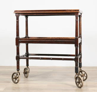 Regency Style Bamboo Form Bar Cart: Regency style bamboo form bar cart. 20th century. Two tiers, carved wooden bamboo form, large rubber casters. Wear, marks, and staining throughout wood of tiers. Scratches, marks and scuffs throughout