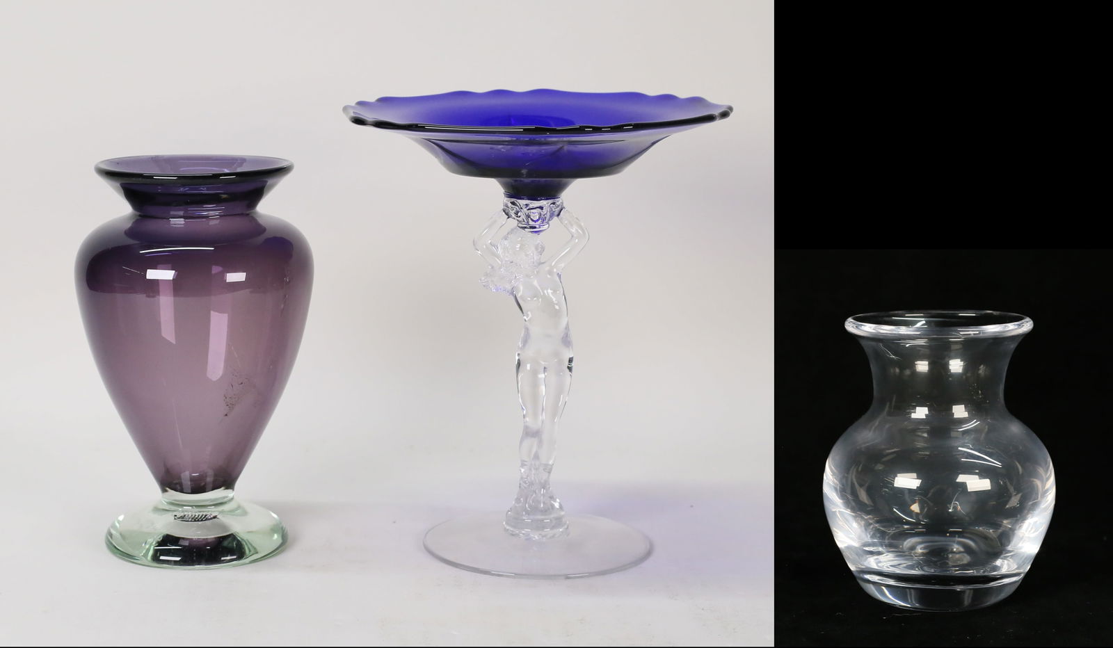 3 Pieces Art Glass Cambridge, Simon Pearce, Hahn: 3 pieces art glass. Michael Hahn amethyst to clear vase, signed and dated '95 on the underside, 7"H; Simon Pearce vase with original box, 4 1/8"H; Cambridge figural compote, nude supporting a cobalt d