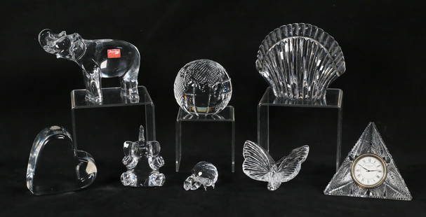 8 Piece Crystal Lot Steuben, Baccarat, Swarovski: 8 piece crystal lot. 4 pieces Waterford: shell paperweight, 4 1/8"H; globe paperweight, 3"H; butterfly, 2"H, Times Square 2000 clock, 3 5/8"H. 3 pieces Baccarat: heart paperweight, 1 1/4"H; 2 elephant