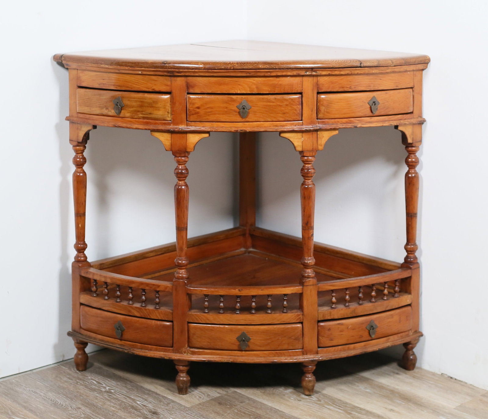 William and Mary Style Corner Table: William and Mary style corner table. 20th century. Six drawers with brass pulls and lower tier. Large split and crack to wood across top. Scratches and marks to wood of top. Wear and scratches to wood
