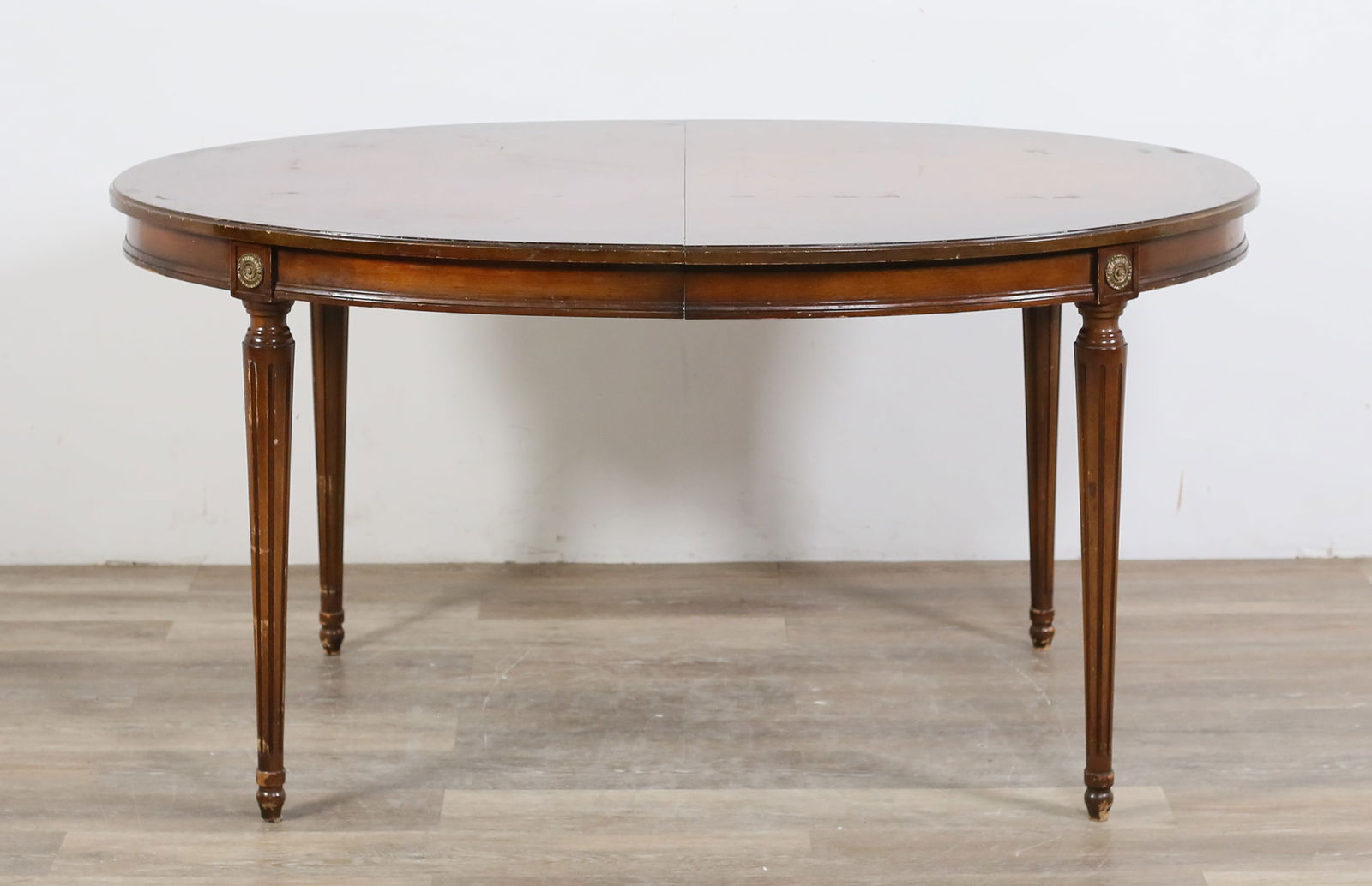 Louis XVI Style Dining Table: Louis XVI style dining table. 20th century. Burlwood top and colonnade legs. Scratches, marks, scuffs and wear throughout top and edges of table. Chips and losses to molding and edges throughout. Scra