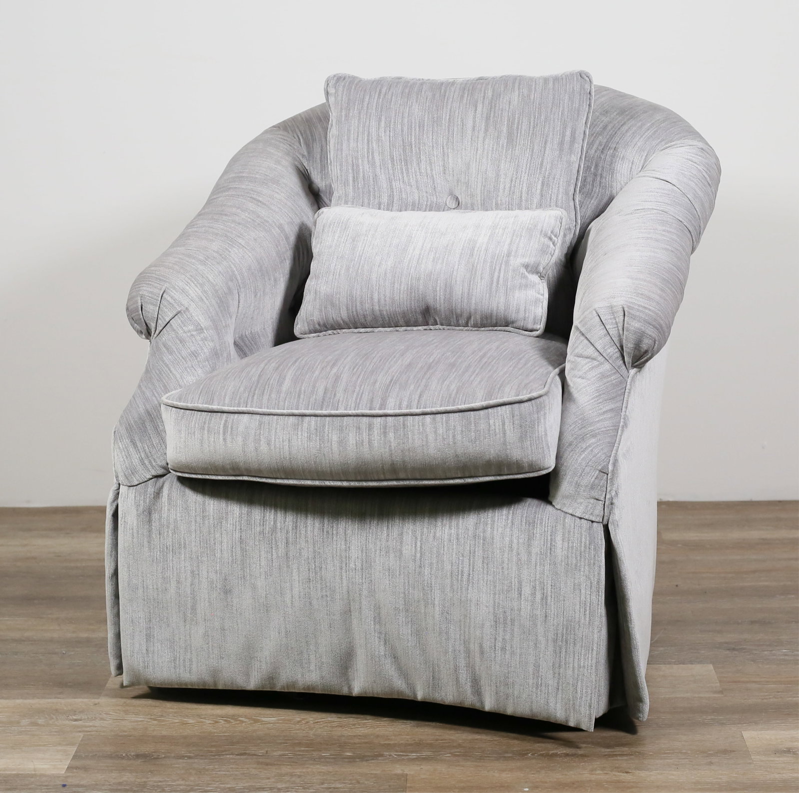 Contemporary Upholstered Swivel Lounge Chair: Contemporary upholstered swivel lounge chair. 21st century. Silvertone upholstery and two throw pillows. No apparent labels or maker's marks. Light fading and wear throughout lounge chair. 32" W x 30"