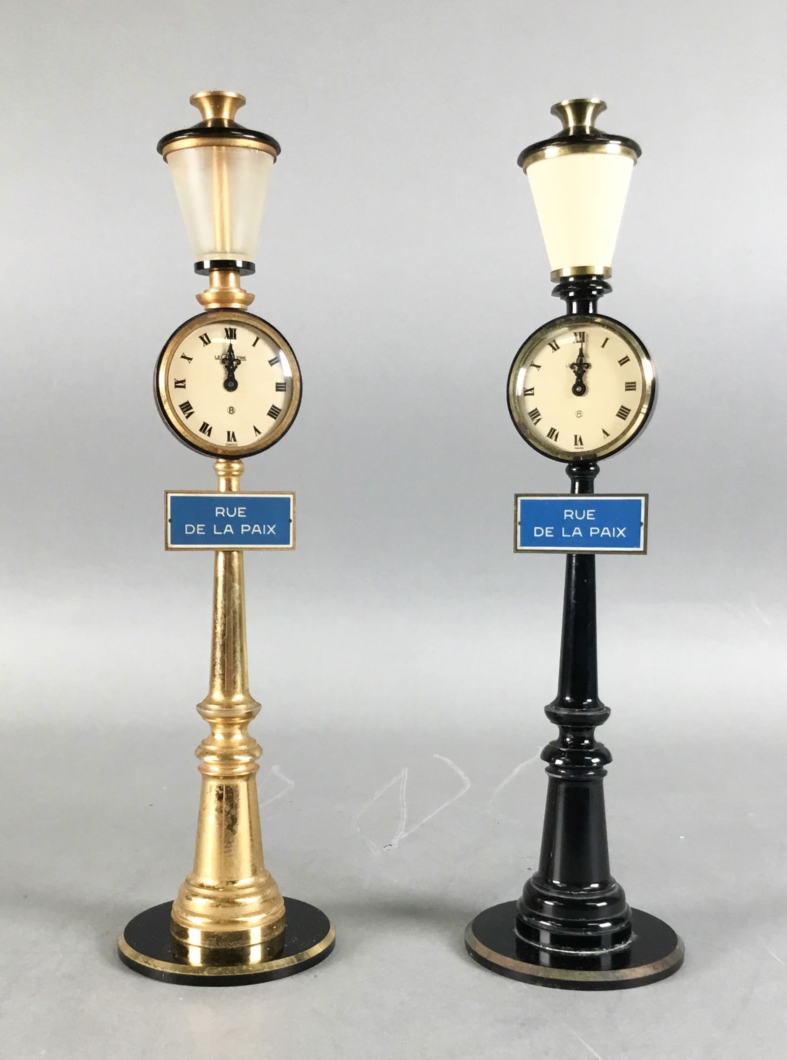2 LeCoultre Rue De Paix Street Lamp Clocks: 2 LeCoultre Rue De La Paix streetlight 8 days desk / table clocks. Faces both marked LeCoultre Swiss. Neither running. Each 11 1/8"H. Both with wear, paint loss and scratches throughout.