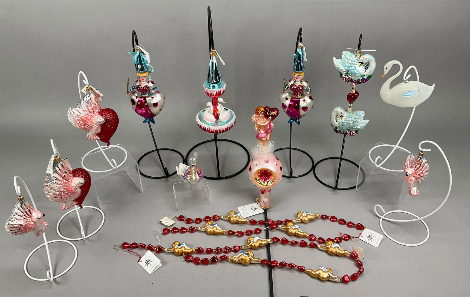 14 Radko Fraga V-Day Ornaments/Garland Swan, Birds: 14 Radko Fraga V-Day Ornaments and Garland Most w/ Tags. Includes Cupids Love Finial Topper #00-189-0, Swan Fountain, Miss Valentine #973210 (x2), Swan Cascade #02-0276-0, Cupid Flight Garland #973440
