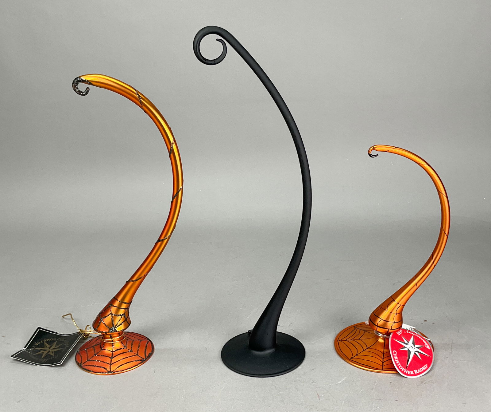 3 Radko Halloween Ornament Holders Orange Black: 3 Radko Halloween Ornament Holders Most w/ Tags. Includes Glass Ornament Holder Orange - 12", Black Glass Ornament Holder - 13.75" - longest & Orange with Web Print Stand ornament Holder - 9.25" - Sho