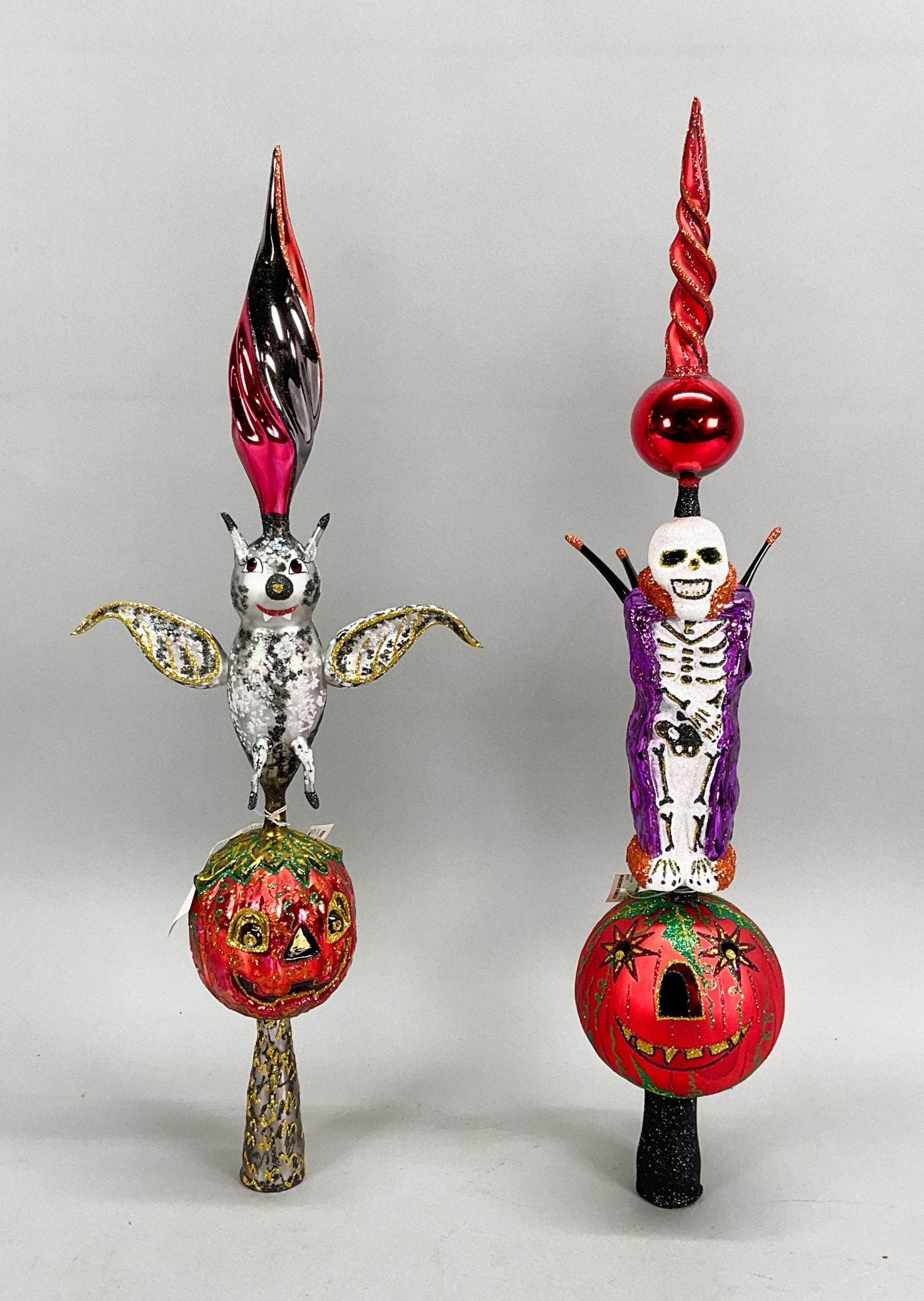 2 Fraga Halloween Toppers Finials with Tags: 2 Fraga Halloween Ornaments with Tags. Includes Pumpkin went Batty - 21" long & Emperor -- 22" long. Some damage to tip.Some wear and paint loss.Ornament stands are NOT INCLUDED.The absence of a condi