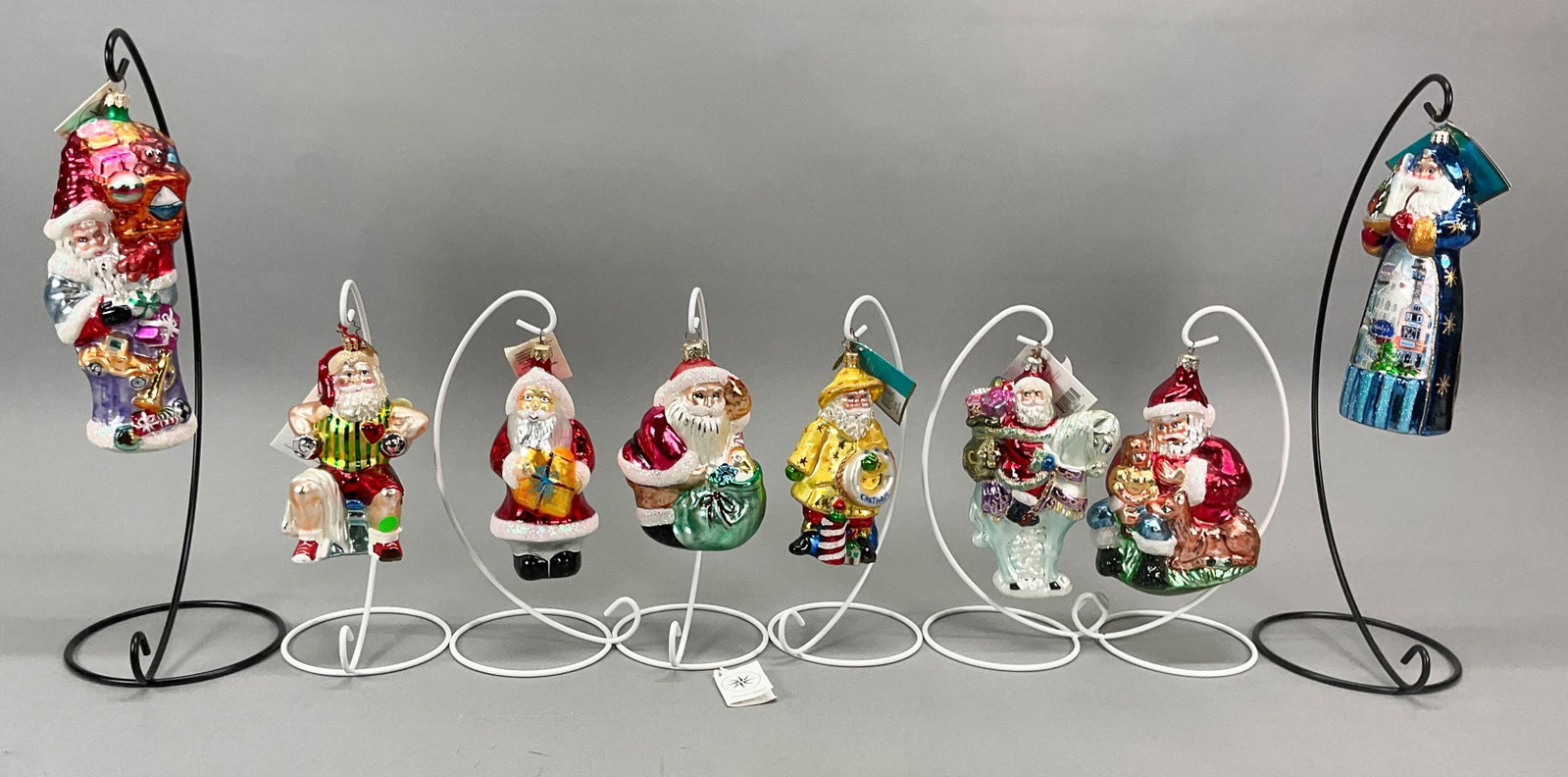 8 Radko Santa Claus Christmas Ornaments: 8 Radko Santa Claus Christmas Ornaments. Most have tags. Includes Norwegian Santa #00-098-0 70323, Seaboard Santa #3011480, Fit Nick, (has some missing paint on left knee and left arm and right elbow)